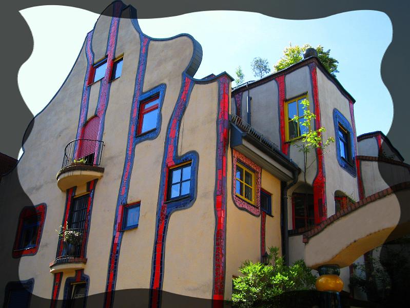 hundertwasser06.JPG - Typisch für die gesamte Wohnanlage sind die  senkrecht nach unten fliesenden, blau eingefassten roten Bänder.  Zitat: Hundertwasser  "Gerade Wände wären gottlos"