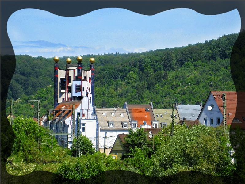 hundertwasser26.JPG - Blick auf Plochingen mit Regenturm. Die Aussenfront der Anlage sieht schlicht aus und wurde auch nicht von Hundertwasser entworfen. Im Vordergrund die Bahnlinie Hamburg - München. Mehr als 500 Züge fahren täglich hier vorbei.